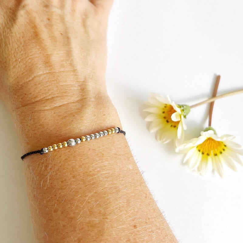 Morse Code Beaded Bracelet - Be You on black cord on a woman's wrist