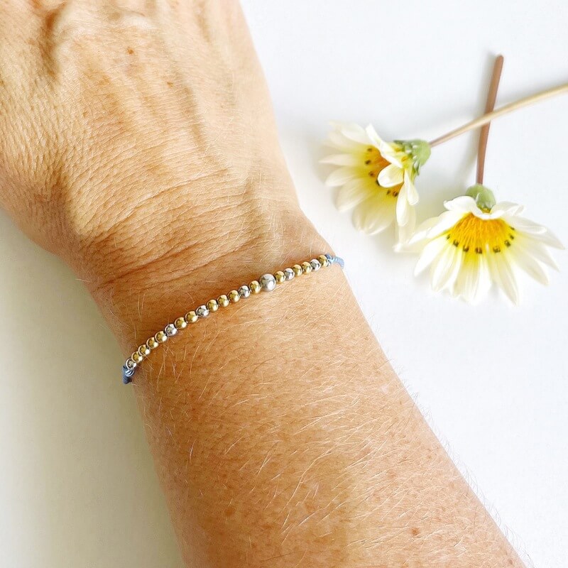 Morse Code Beaded Bracelet - Brave AF with light blue cord on woman's wrist