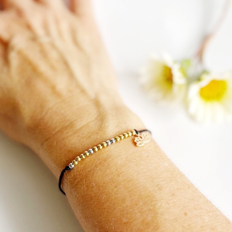 Breathe Morse Code and Charm Beaded Bracelet with lotus charm on black cord on woman's wrist