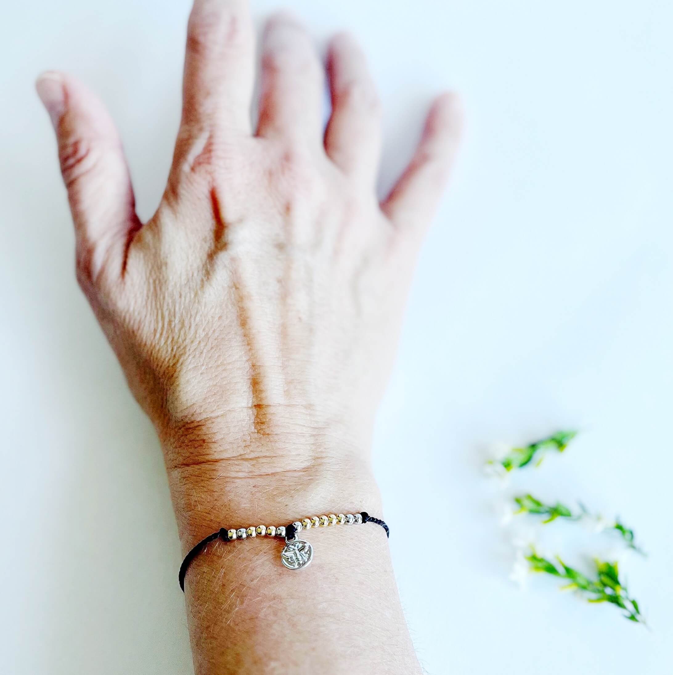 Let Them Morse Code and Charm Bracelet with a bee charm on a woman's wrist