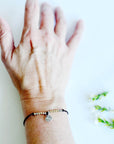 Let Them Morse Code and Charm Bracelet with a bee charm on a woman's wrist