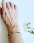 Let Them Morse Code and Charm Bracelet with a heart charm on a woman's wrist