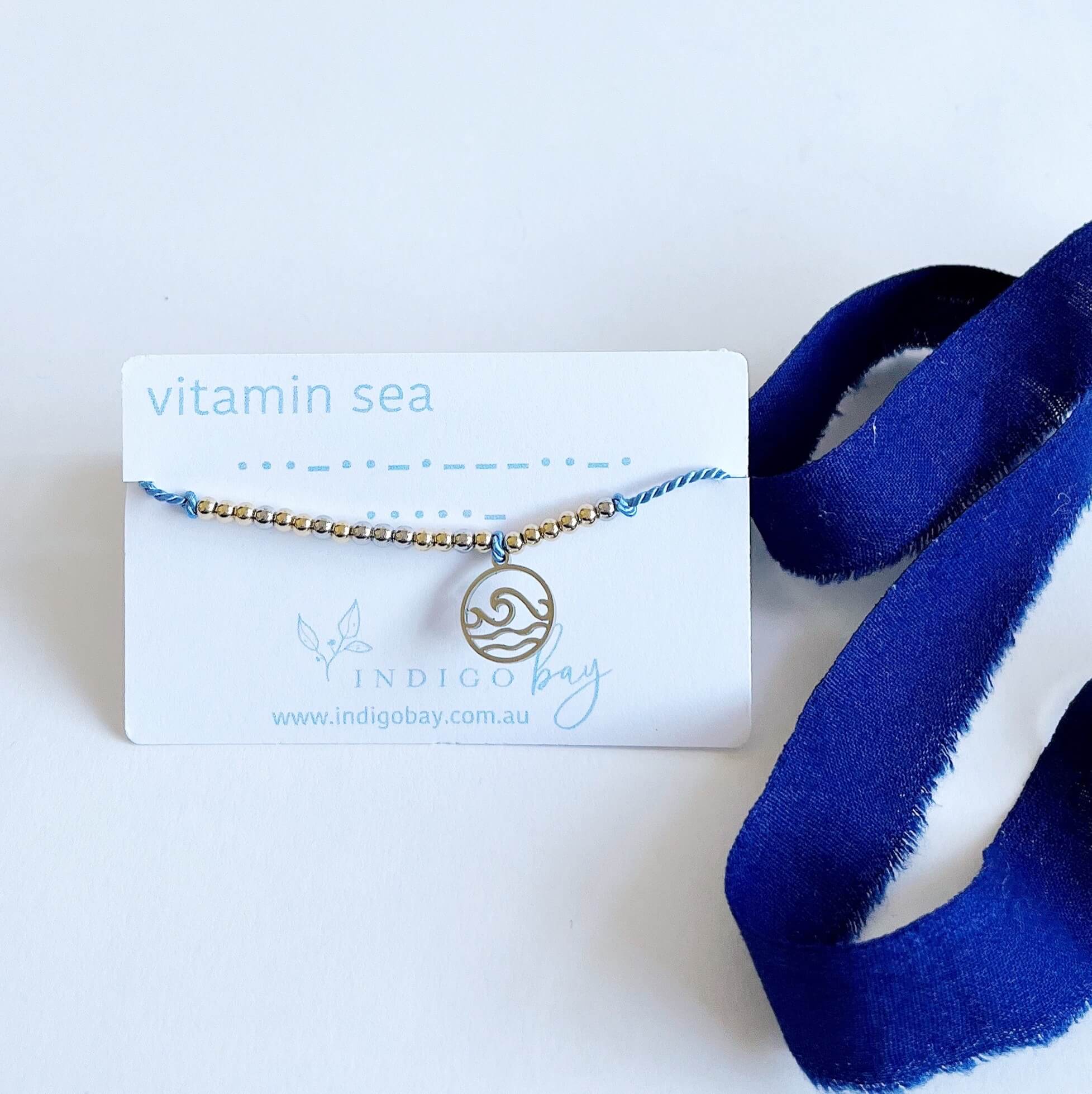 Vitamin Sea Morse Code and Charm bracelet with a wave charm light blue cord.