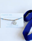 Vitamin Sea Morse Code and Charm bracelet with a wave charm light blue cord.