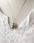 Round cage locket with green ribbon inside - Write Your Wish Necklace - on a model