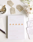 White self-care notepad with orange text and orange rainbows