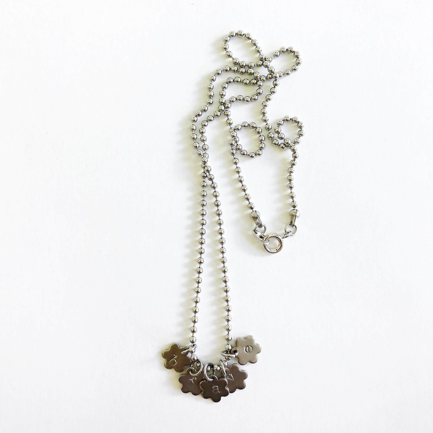 Flower charm necklace on ball chain stamped with "brave"