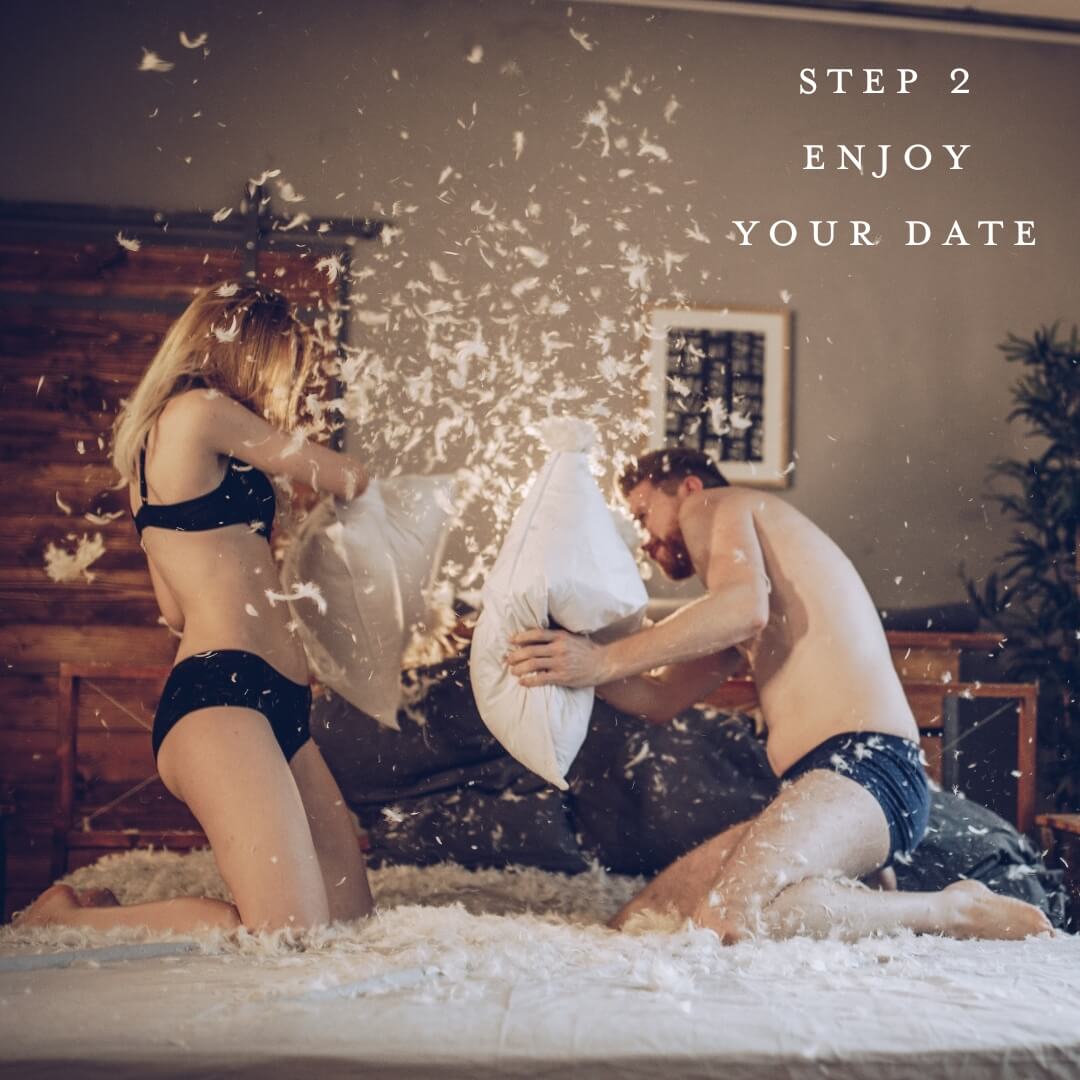 A couple having a pillow fight on a bed with the text "Step 2 Enjoy Your Date"