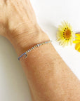 Moon and back Morse Code Beaded Bracelet with moon charm on light blue cord on a woman's wrist
