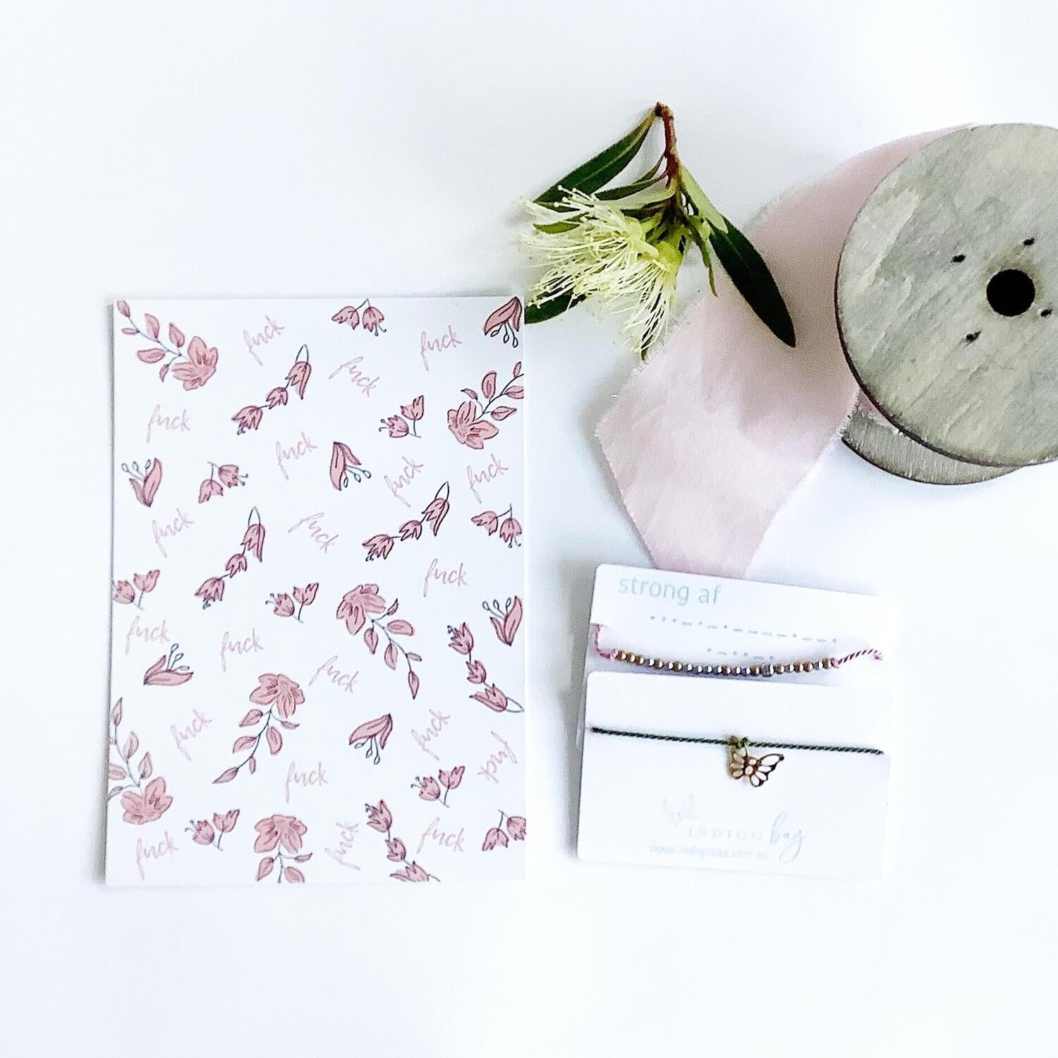 White postcard with pink flowers and &#39;fuck&#39; scattered throughout the flowers