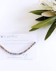 Fuck perfect Morse code beaded bracelet on light blue cord on a white card with blue text