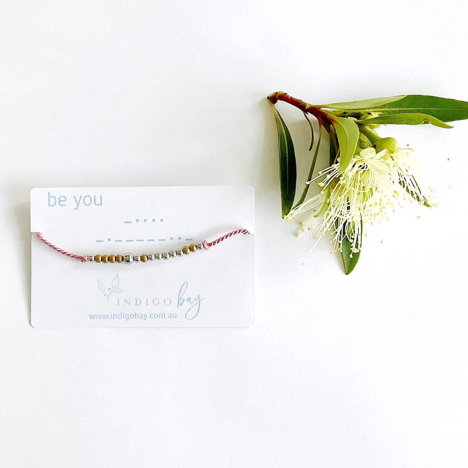 Be you beaded bracelet on a white card with blue text