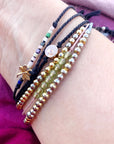 6 beaded and charm bracelets on a woman's wrist