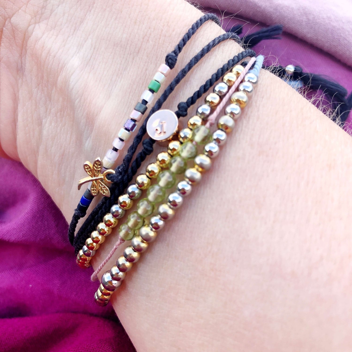 6 beaded and charm bracelets on a woman&#39;s wrist