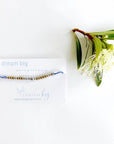 Dream big Morse code beaded bracelet on light blue cord on a white card with blue text